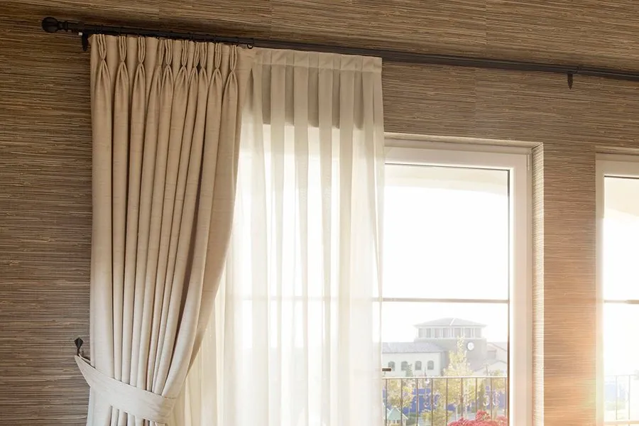 Cortinas de tela con visillo junto a una ventana